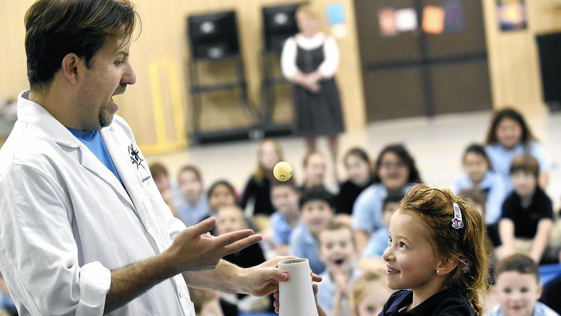 With help from Eric Krupkin, left, kindergartener Savannah Smith, right, keeps a ping pong ball aloft using a hair dryer during Krupkin's 'Eric Energy' science presentation at Carroll Lutheran School in Westminster Wednesday, March 16, 2016.