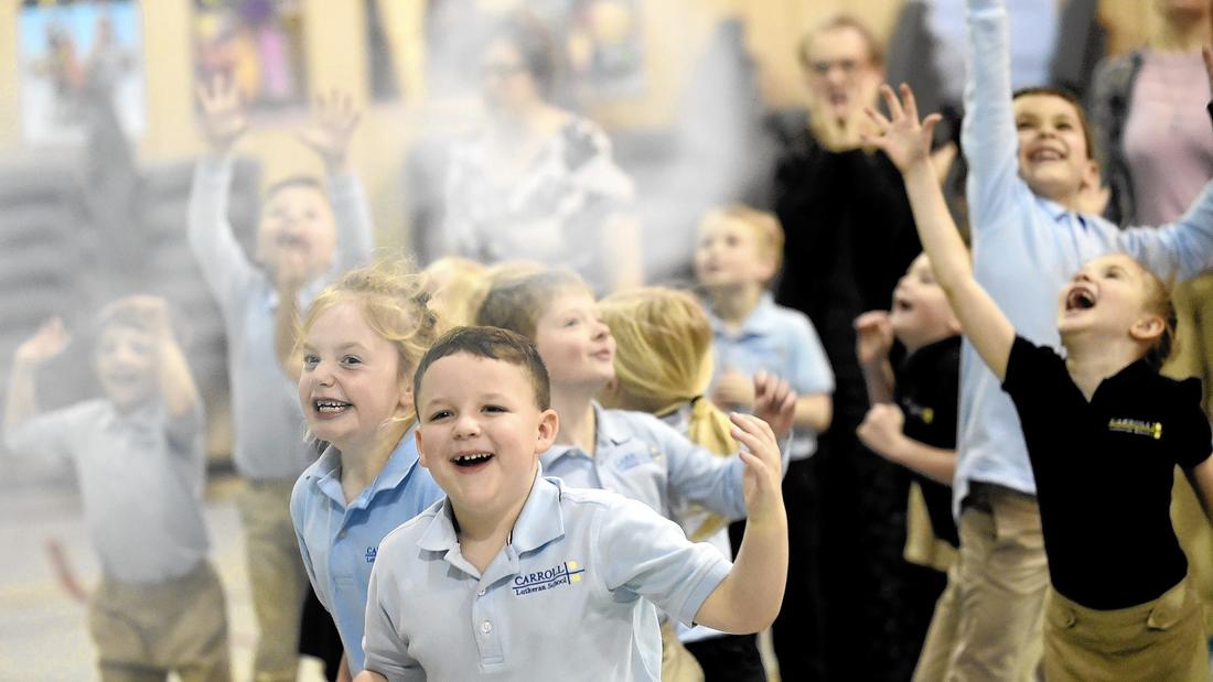 Students, including kindergarteners Allie Keller and Carter Leonard try to grab vapor rings created by a vortex generator during a science presentation by 'Eric Energy' at Carroll Lutheran School in Westminster Wednesday, March 16, 2016